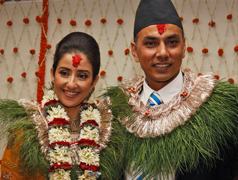 Bollywood actress Manisha Koirala, left, poses for photographs with groom Samrat Dahal before getting married in Katmandu, Nepal, Friday, June 18, 2010. Koirala's marriage ceremonies with Dahal, a Nepalese businessman, are spread over three days and will be attended by family and close friends. (AP Photo/Binod Joshi)